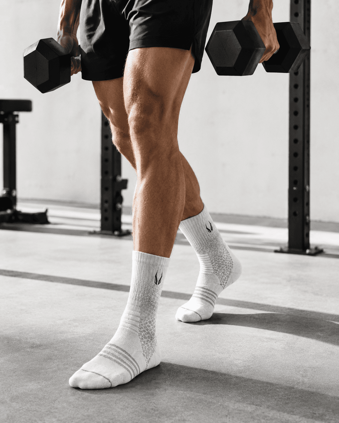 Male athlete strength training in warm indoor light — HOOF performance socks